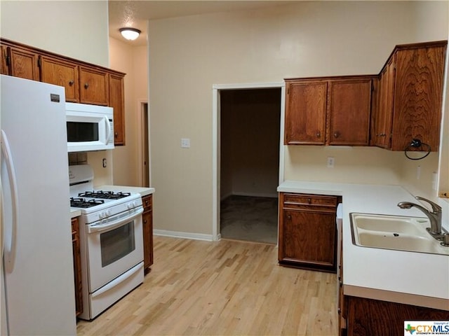1502 Stratford Dr, Killeen, TX 76549 - kitchen featuring white appliances, light wood-type flooring, light countertops, and brown cabinets