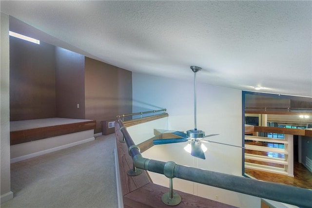 interior space with carpet floors, a textured ceiling, and baseboards