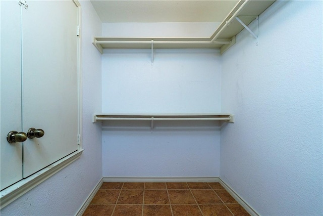 spacious closet with dark tile patterned floors