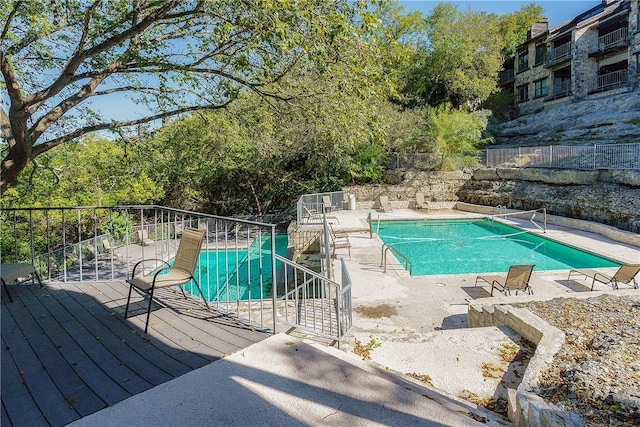 community pool with fence and a patio