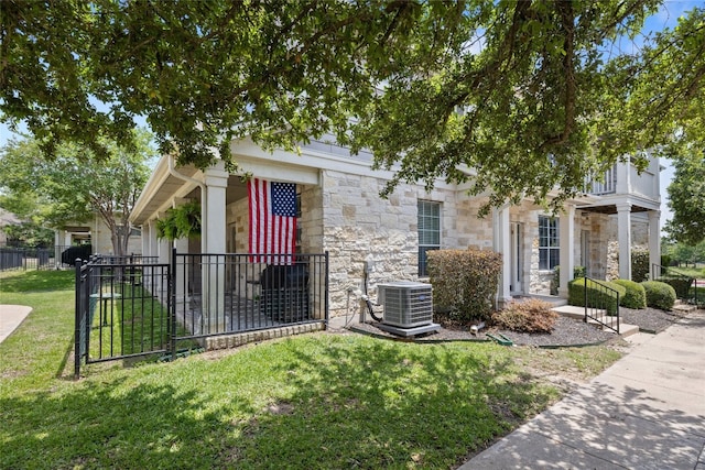 1900 Scofield Ridge Parkway Unit 1903, Austin, TX 78727 - view of property hidden behind natural elements featuring fence, central AC unit, a front yard, and stone siding