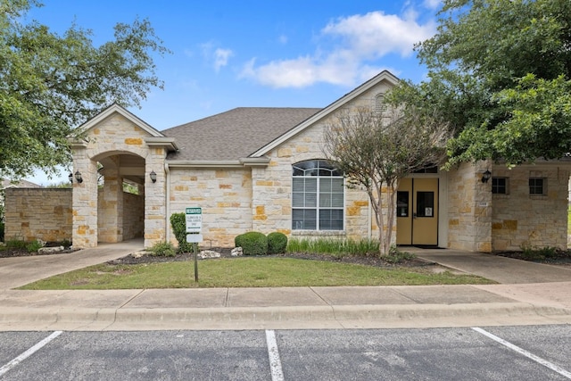 1900 Scofield Ridge Parkway Unit 1903, Austin, TX 78727 - view of front of house with roof with shingles, a front lawn, uncovered parking, and stone siding
