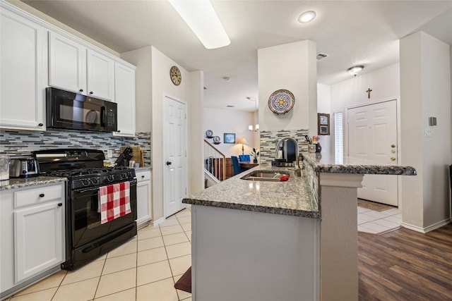 1900 Scofield Ridge Parkway Unit 1903, Austin, TX 78727 - kitchen with a peninsula, white cabinets, tasteful backsplash, a sink, and black appliances