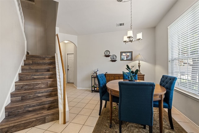 1900 Scofield Ridge Parkway Unit 1903, Austin, TX 78727 - dining room featuring arched walkways, a notable chandelier, light tile patterned flooring, and stairway