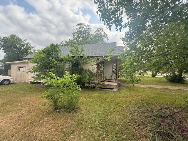 view of front facade featuring a front lawn and roof with shingles
