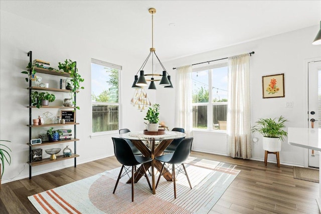 dining room featuring baseboards, wood finished floors, and a chandelier
