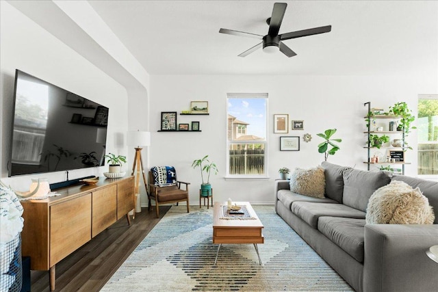 living room with baseboards, dark wood finished floors, and ceiling fan