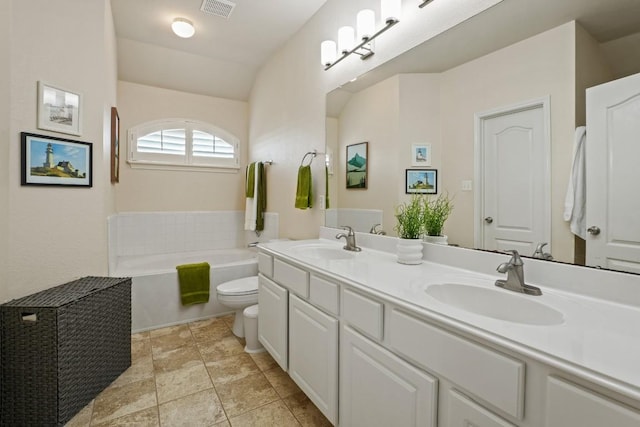 full bathroom with toilet, a garden tub, double vanity, and a sink