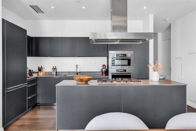 210 Lavaca St Unit 2308, Austin, TX 78701 - kitchen with a sink, island exhaust hood, dark wood-type flooring, visible vents, and appliances with stainless steel finishes
