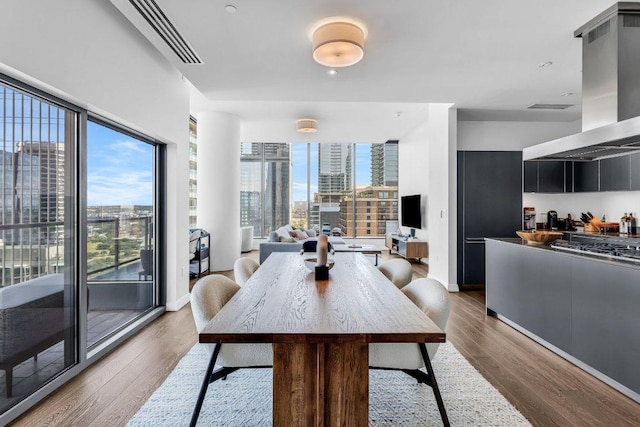 210 Lavaca St Unit 2308, Austin, TX 78701 - dining area featuring baseboards, visible vents, and wood finished floors