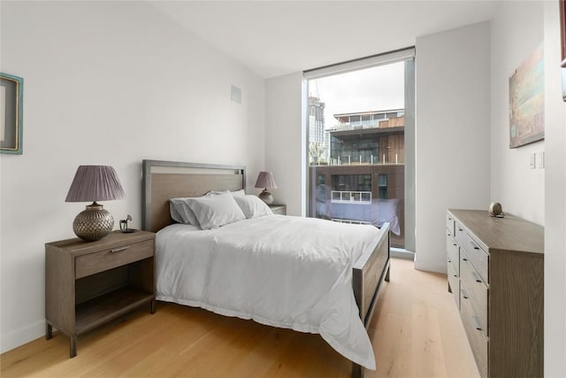 44 E Ave Unit 2907, Austin, TX 78701 - bedroom featuring a wall of windows and light wood-type flooring