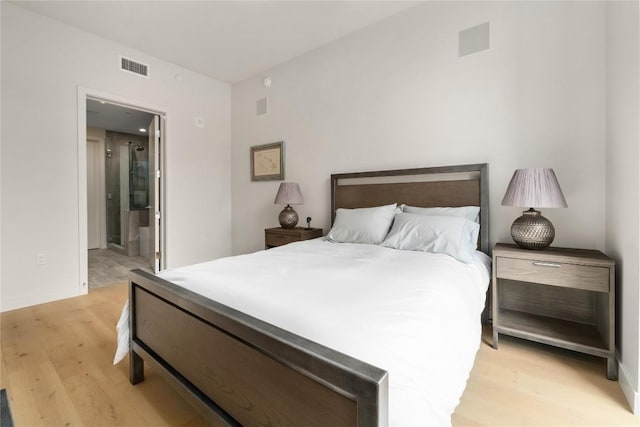 44 E Ave Unit 2907, Austin, TX 78701 - bedroom featuring ensuite bathroom, light wood-style flooring, baseboards, and visible vents