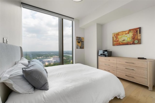 44 E Ave Unit 2907, Austin, TX 78701 - bedroom with floor to ceiling windows, light wood-style flooring, and multiple windows
