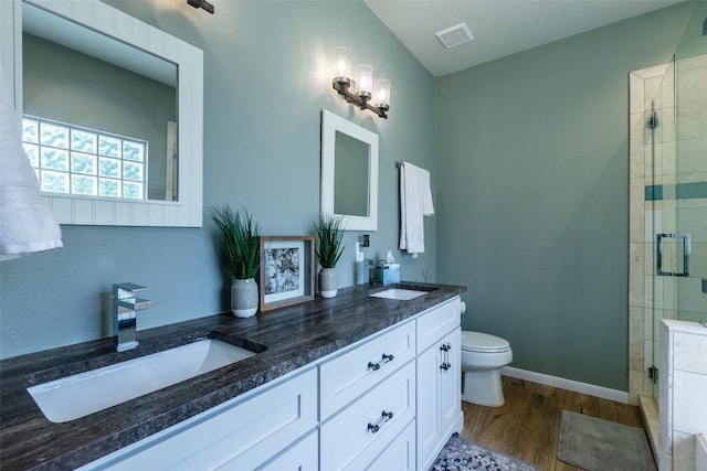 511 Shadywood Ln, Dripping Springs, TX 78620 - bathroom featuring wood finished floors, a shower stall, double vanity, toilet, and baseboards