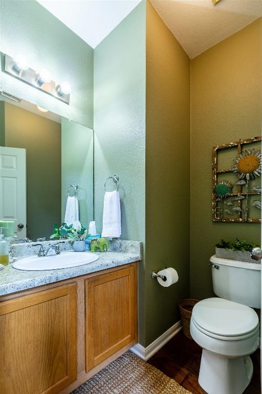 511 Shadywood Ln, Dripping Springs, TX 78620 - bathroom with vanity, toilet, baseboards, and wood finished floors