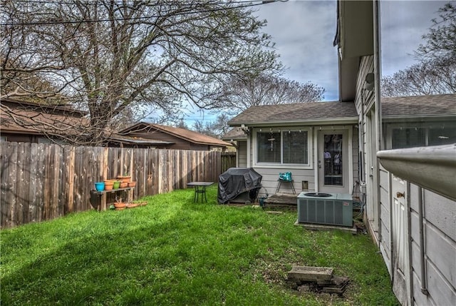 view of yard with central AC unit and fence