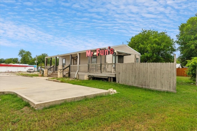 1002 College St, Bastrop, TX 78602 - rear view of house with a lawn and fence