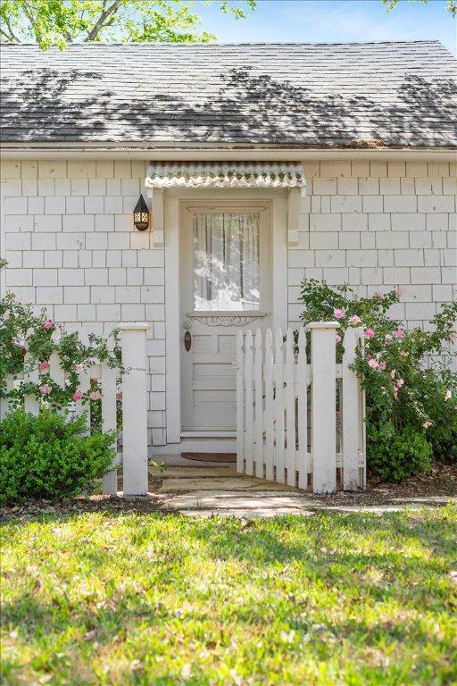 doorway to property featuring a shingled roof