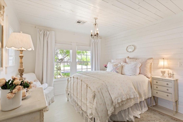 carpeted bedroom with a chandelier, wood ceiling, and visible vents