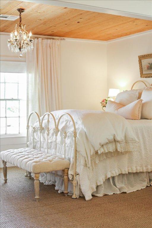 bedroom with an inviting chandelier, wood ceiling, visible vents, and ornamental molding
