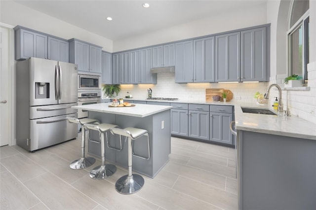 14912 Swallow Tailed Kite Dr, Austin, TX 78738 - kitchen featuring stainless steel appliances, decorative backsplash, a center island, a breakfast bar, and recessed lighting