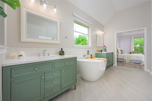 ensuite bathroom featuring vanity, lofted ceiling, ensuite bathroom, and a freestanding tub