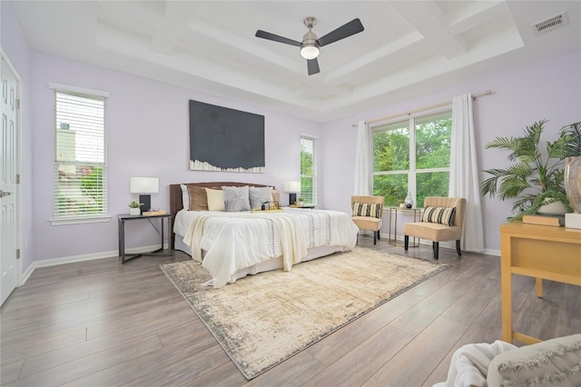 14912 Swallow Tailed Kite Dr, Austin, TX 78738 - bedroom featuring coffered ceiling, multiple windows, wood finished floors, beam ceiling, and a tray ceiling