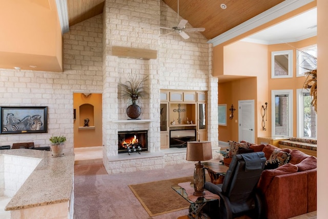 living area with wooden ceiling, ornamental molding, ceiling fan, high vaulted ceiling, and a large fireplace