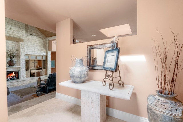 interior space with baseboards, a skylight, and a fireplace