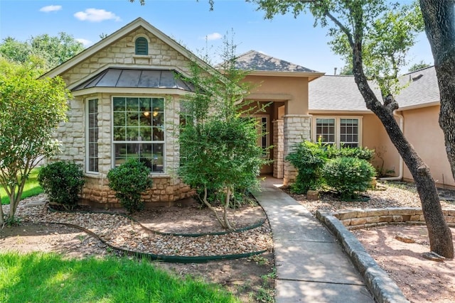 105 Saddle Trl, Georgetown, TX 78633 - view of front of home with stone siding, stucco siding, roof with shingles, and a standing seam roof