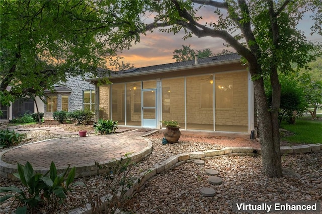 105 Saddle Trl, Georgetown, TX 78633 - back of property at dusk with a sunroom and a patio
