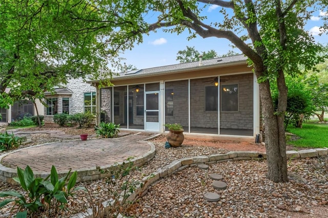 105 Saddle Trl, Georgetown, TX 78633 - rear view of house with stone siding, a patio area, and a sunroom