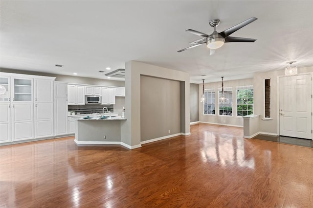 105 Saddle Trl, Georgetown, TX 78633 - unfurnished living room with baseboards, wood finished floors, recessed lighting, and ceiling fan with notable chandelier