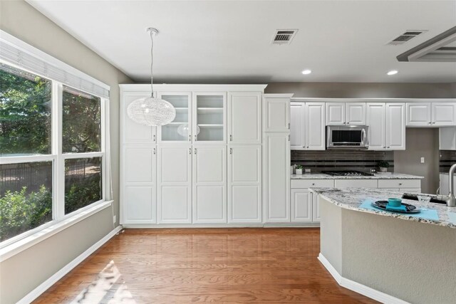 105 Saddle Trl, Georgetown, TX 78633 - kitchen featuring stainless steel microwave, decorative light fixtures, white cabinetry, and visible vents