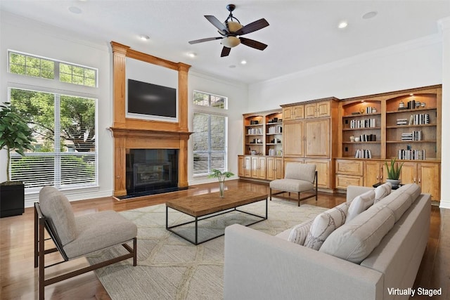 110 Woodall Dr, Georgetown, TX 78628 - living area with light wood finished floors, ornamental molding, a large fireplace, and a ceiling fan