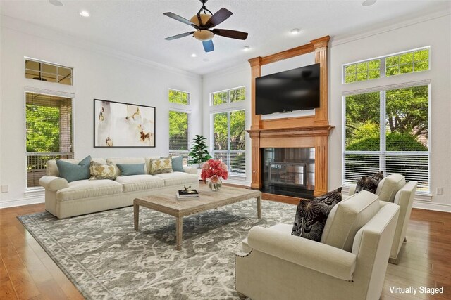 110 Woodall Dr, Georgetown, TX 78628 - living room with crown molding, a large fireplace, a ceiling fan, wood finished floors, and recessed lighting
