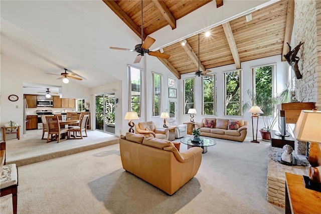 living area with high vaulted ceiling, light carpet, a wealth of natural light, a ceiling fan, and wood ceiling