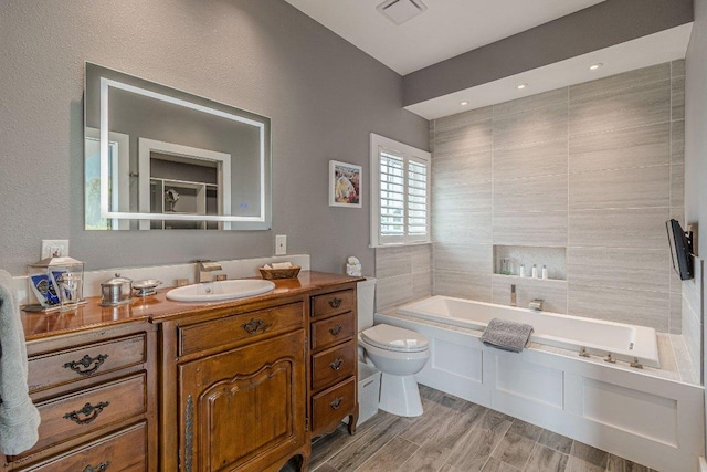 770 Stanton Rd, Johnson City, TX 78636 - bathroom with toilet, a bath, vanity, and wood finished floors