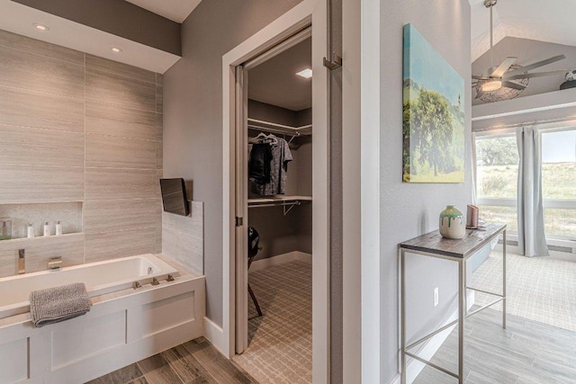 770 Stanton Rd, Johnson City, TX 78636 - full bathroom featuring wood finished floors, a ceiling fan, a garden tub, a spacious closet, and baseboards