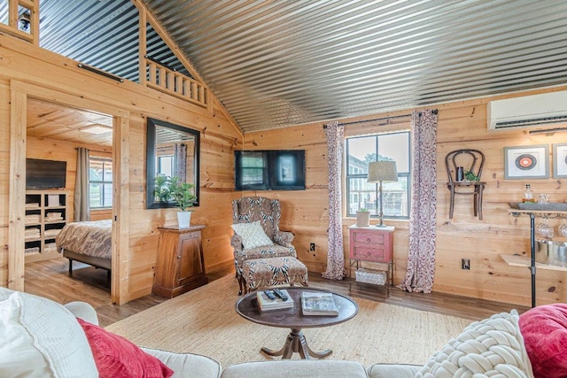 770 Stanton Rd, Johnson City, TX 78636 - living room with a wall mounted air conditioner, wood walls, wood finished floors, healthy amount of natural light, and high vaulted ceiling