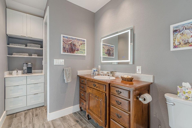 770 Stanton Rd, Johnson City, TX 78636 - bathroom with wood finished floors, vanity, toilet, and baseboards