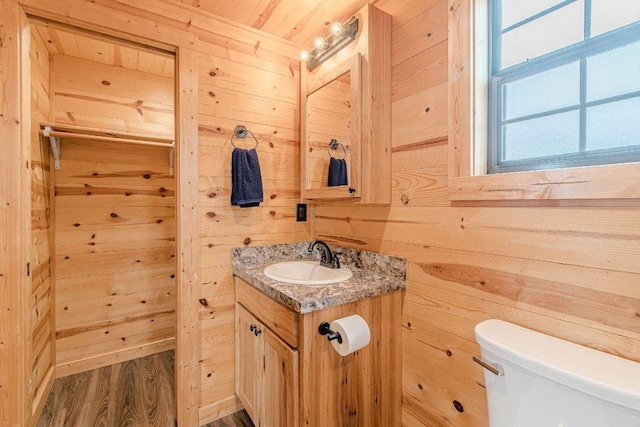 770 Stanton Rd, Johnson City, TX 78636 - bathroom with wooden walls, toilet, vanity, and wood finished floors