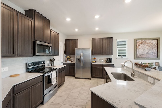 130 Mcginnis Trl, Kyle, TX 78640 - kitchen featuring light tile patterned floors, dark brown cabinets, a sink, appliances with stainless steel finishes, and tasteful backsplash