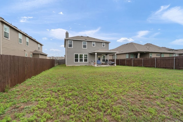 130 Mcginnis Trl, Kyle, TX 78640 - back of property with a yard, a chimney, a patio area, and a fenced backyard