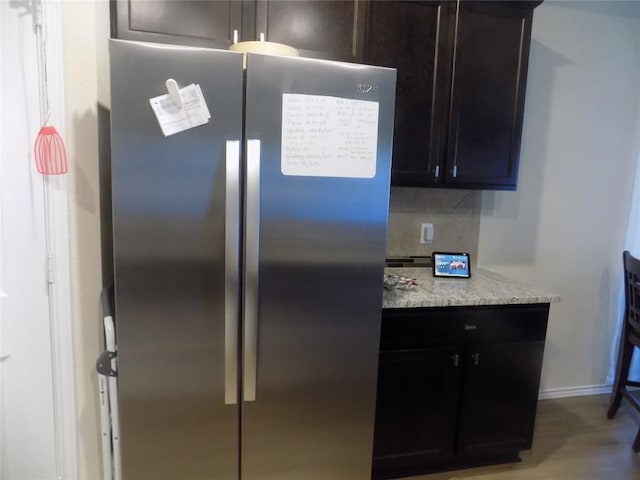 124 Rearden Blvd, Jarrell, TX 76537 - kitchen view of freestanding refrigerator, light stone countertops, baseboards, and decorative backsplash