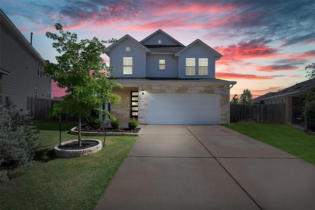 traditional-style home with fence, an attached garage, stone siding, and driveway