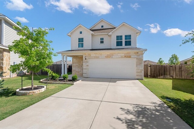 traditional-style house featuring stone siding, an attached garage, fence, concrete driveway, and a front yard