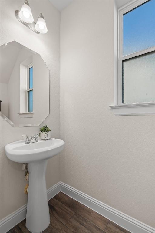 bathroom featuring wood finished floors, baseboards, and a sink