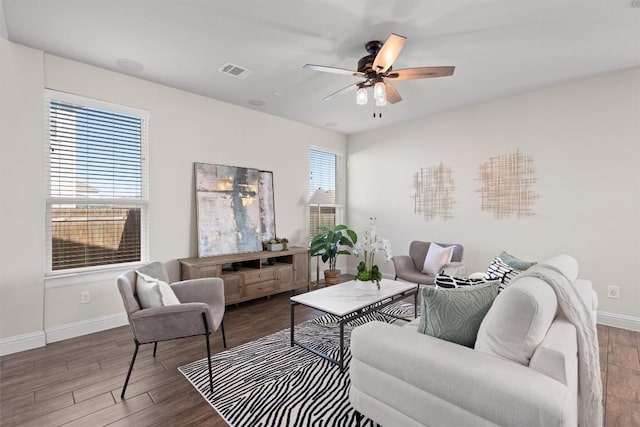 living room with visible vents, wood finished floors, baseboards, and ceiling fan