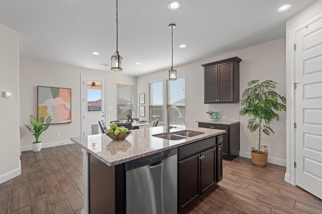 kitchen featuring light stone counters, a sink, stainless steel dishwasher, and dark wood-type flooring